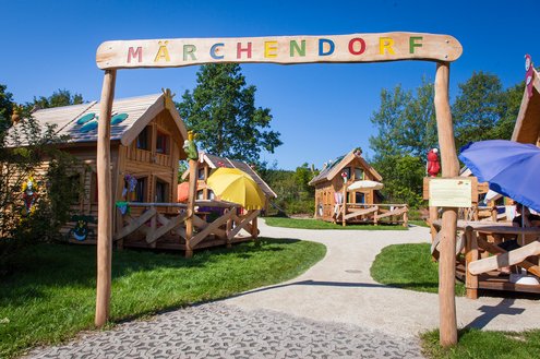 Im Bild ist der Eingang, mit Torbogen, des Märchendorfes des Campingplatz Bostalsee zu sehen.
