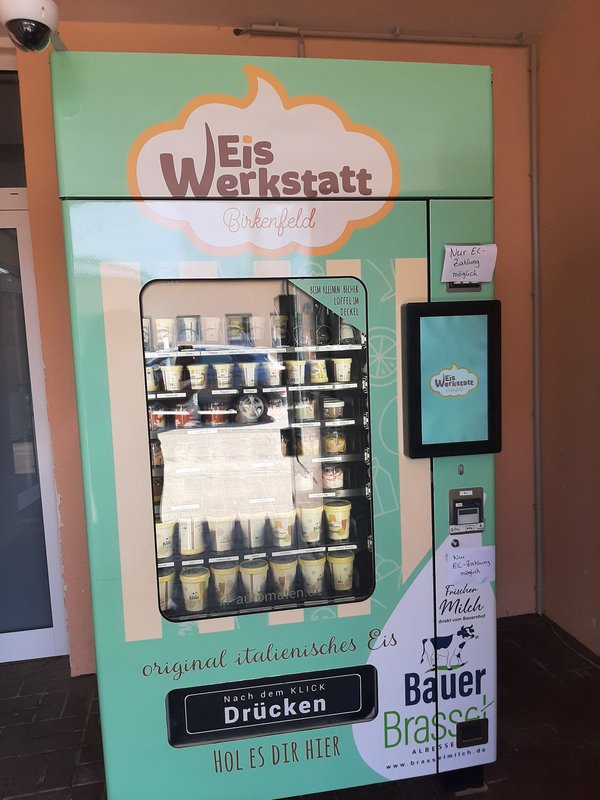 Eisautomat Eiswerkstatt 2025 Frontalsicht aufeinen Automaten der Firma Eiswerkstatt aus Birkenfeld, der mit frischen Eisbechern befüllt ist.