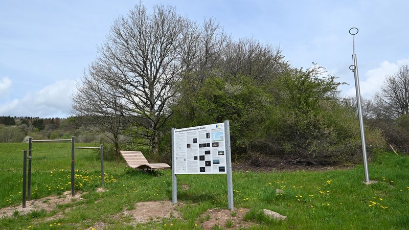 Auf einer grünen Wiese sind eine drehbare Sternkarte mit Infotafel, ein Polarsternfinder mit Peilringen, ein Fernglas- bzw. Teleskopaufsetzer sowie eine dreh- und schwingbare Wellenliege zu finden.