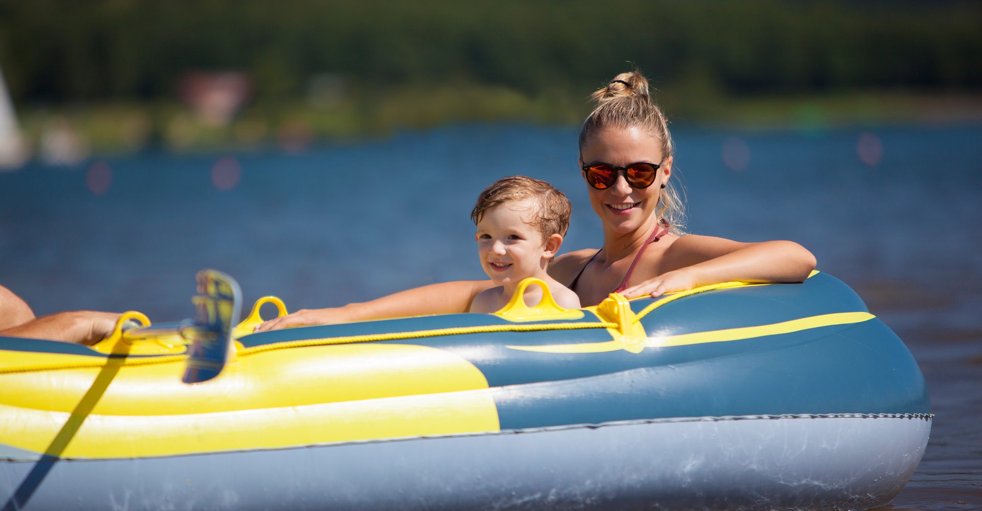 Eine Frau sitzt mit einem kleinen Jungen auf dem Schoß in einem Schlauchboot  auf dem Bostalsee.