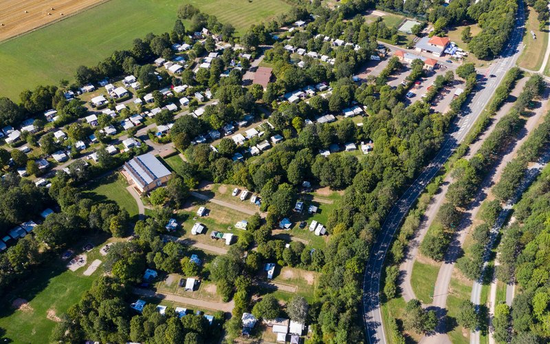 Aus der Luft sieht man, dass der Campingplatz Bostalsee aus mehreren Buchten und über 400 Plätzen besteht und von viel Grün umgeben ist.