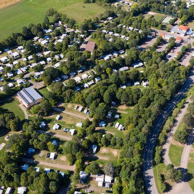 Aus der Luft sieht man, dass der Campingplatz Bostalsee aus mehreren Buchten und über 400 Plätzen besteht und von viel Grün umgeben ist.