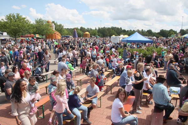 Vor dem Musikpavillon sind Bänke aufgestellt, auf denen die Familien Platz nehmen und die aufgeführten Shows verfolgen können.