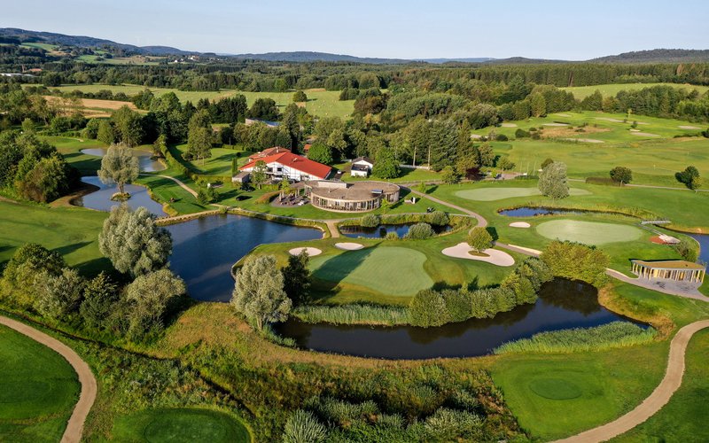 Der Golfplatz Bostalsee liegt inmitten der Natur in einem grünen hügeligen Gelände mit kleinen Teichen, in der Mitte liegt das Hauptgebäude.