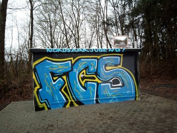 Eine Trafostation ist komplett schwarz besprüht mit der Aufschrift in blau "FCS" und "Nordsaarjugend"