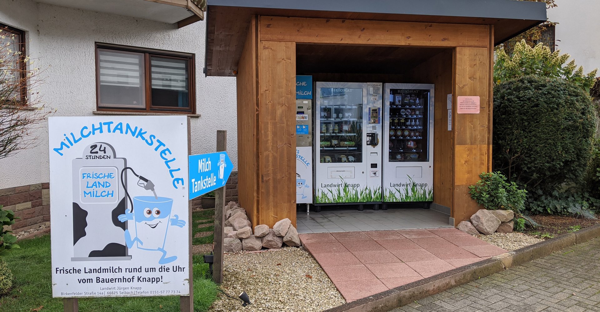 Ein kleines Holzhaus am Straßenrand, in dem man Milch und andere Produkte vom Bauer vor Ort erwerben kann.