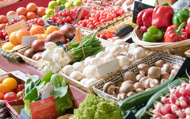 Obst und Gemüse schön nebeneinander aufgereiht auf einem Marktstand.